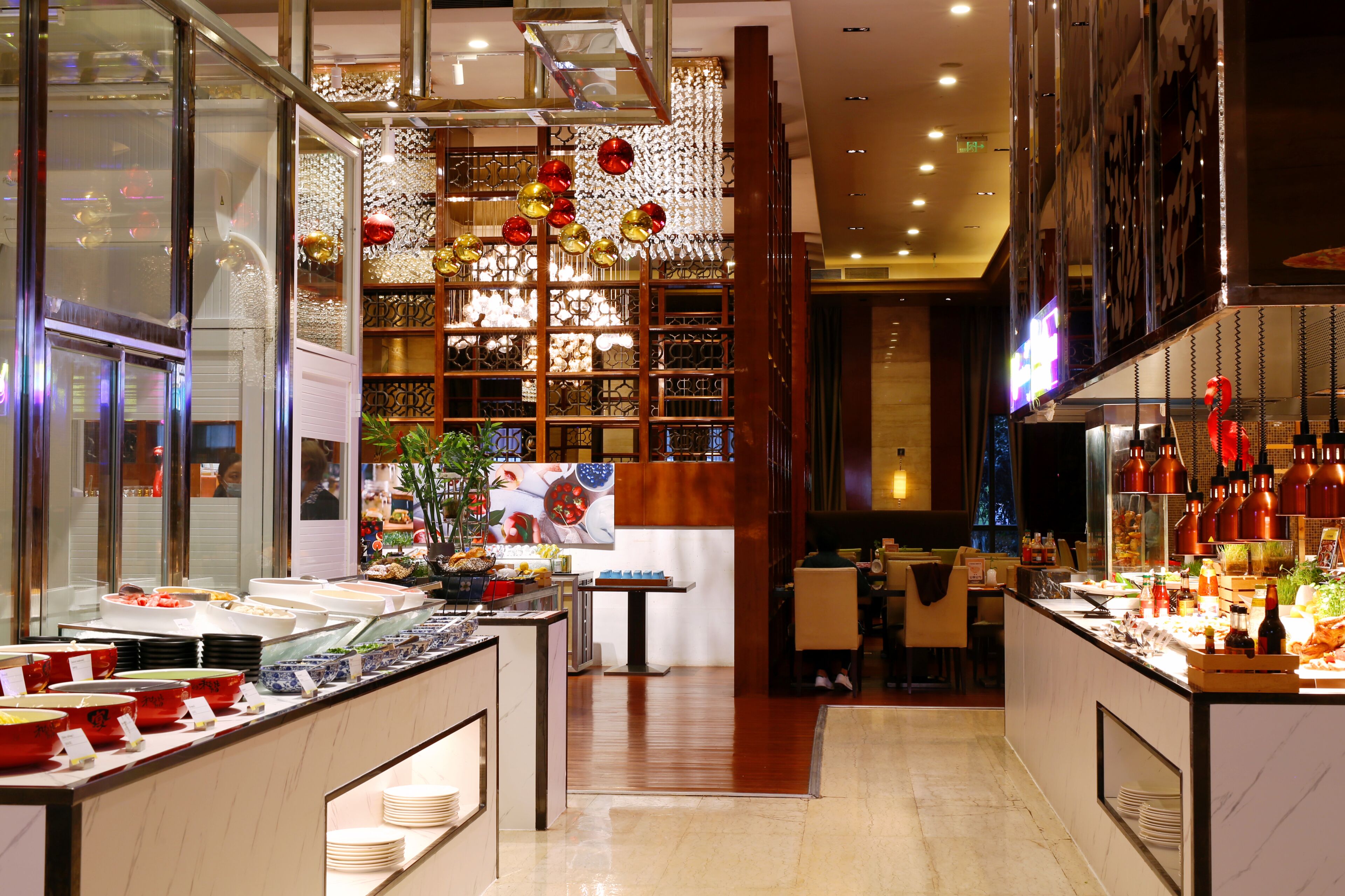 Un espace buffet proposant divers plats et un mur décoratif agrémenté d’ornements suspendus.