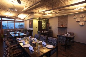 A restaurant with a high ceiling, patterned chairs, and a dining area set for a meal. - juSTa MG Road (Bengaluru)