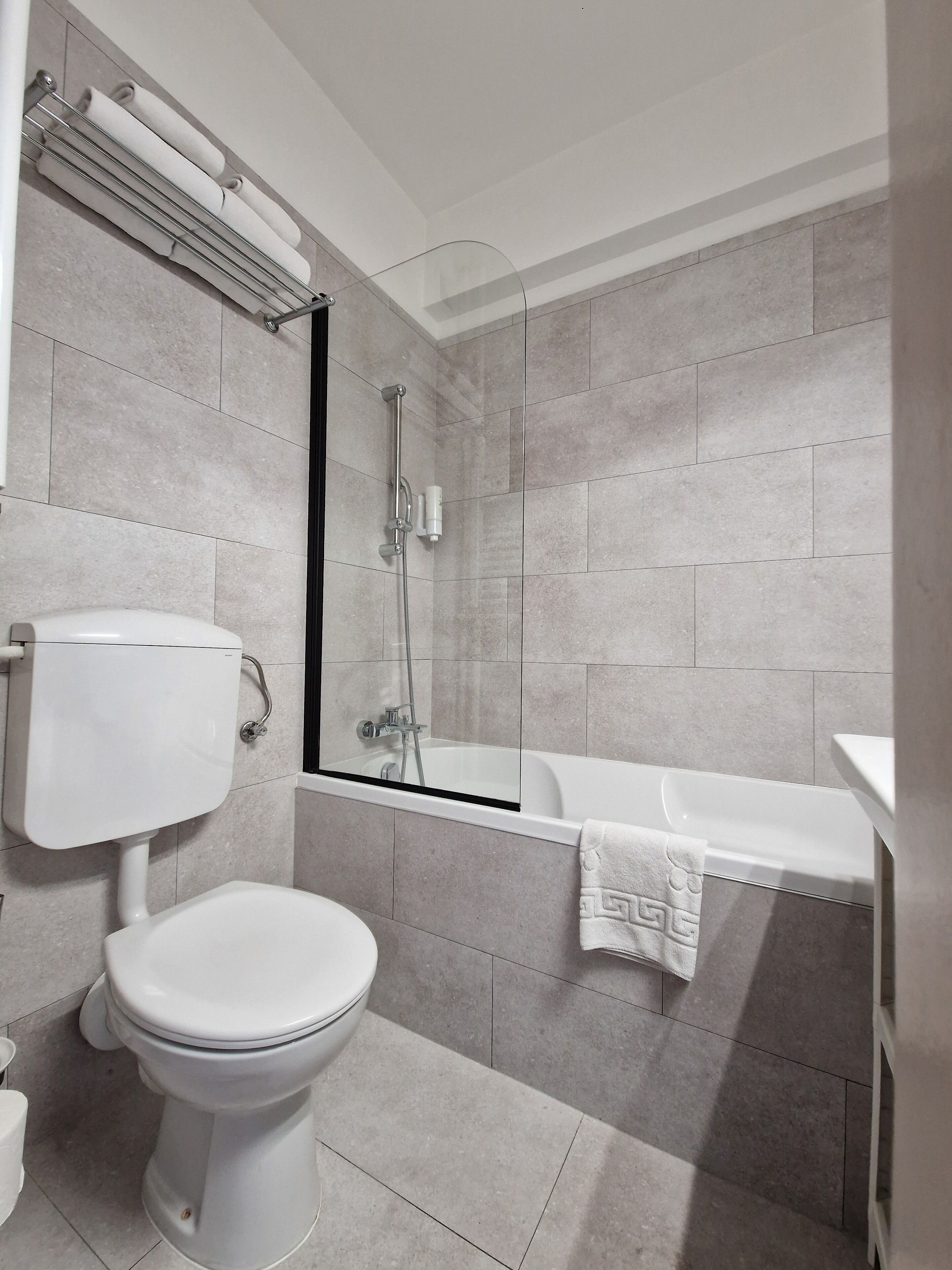 Une salle de bain moderne équipée de toilettes, d’une baignoire et d’une douche.