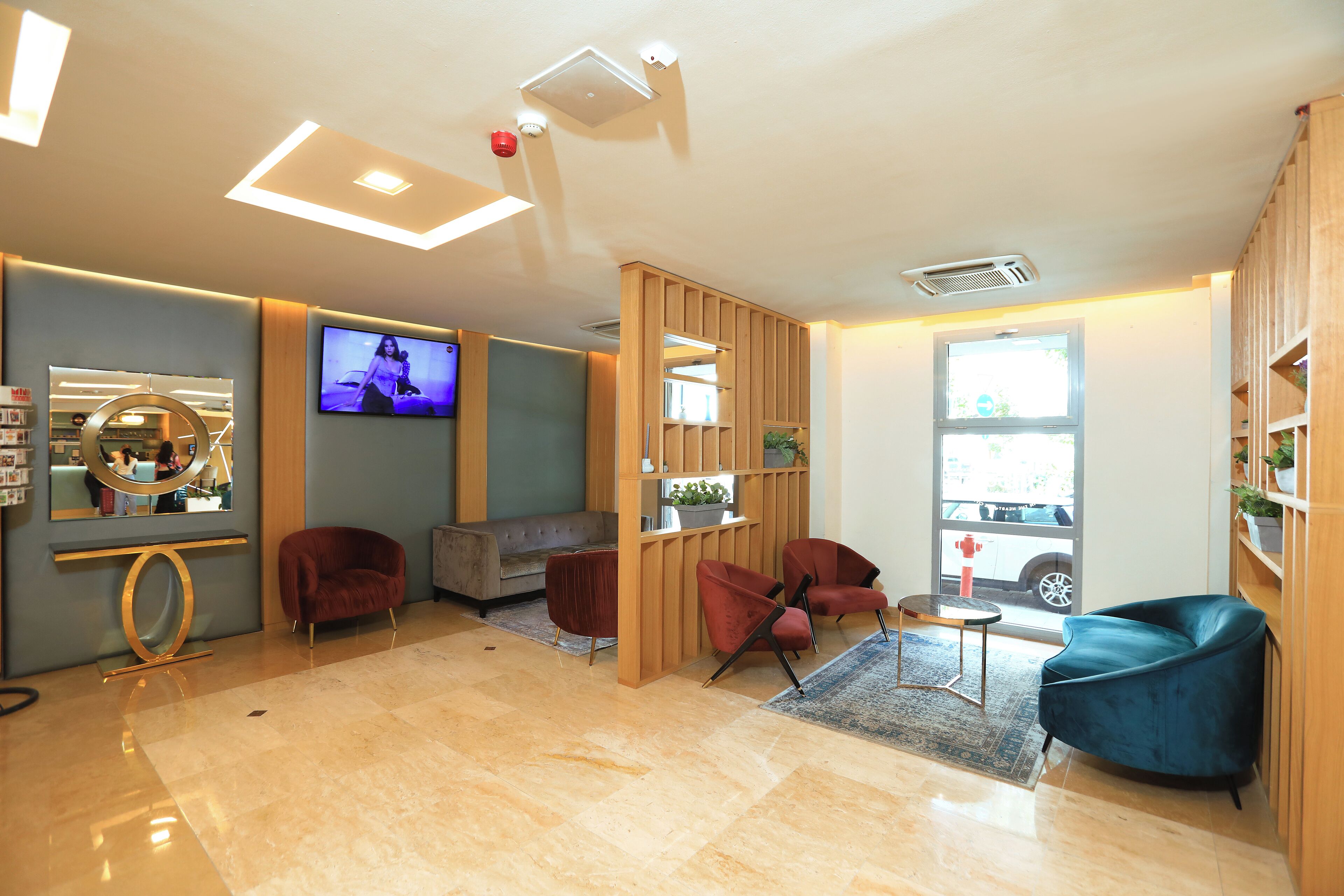 A modern interior with a seating area, a television, and a view of the outside.
