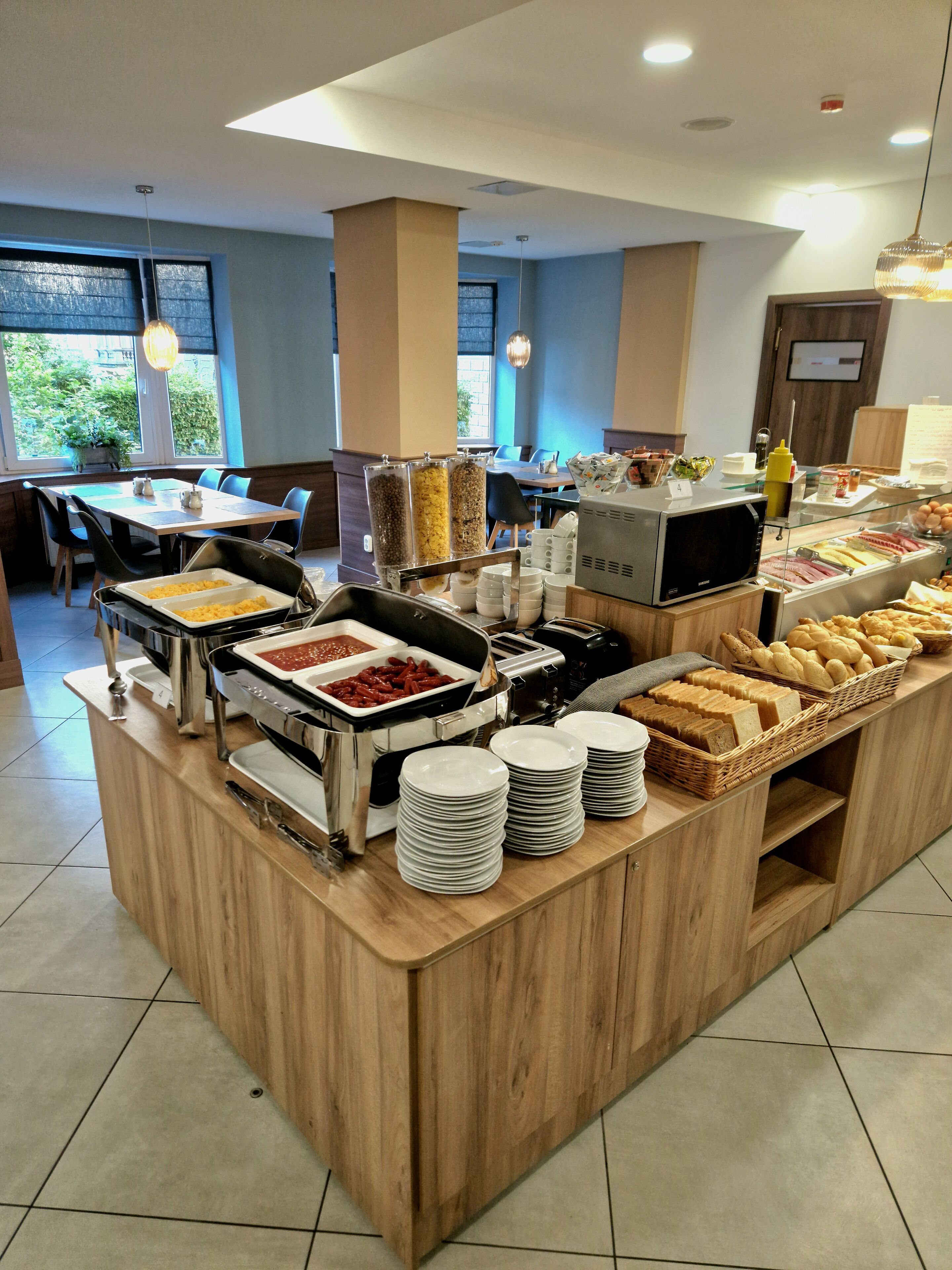 Montaje de bufé con diversos alimentos y un área de estar al fondo.