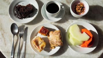Una mesa con diversos alimentos, utensilios y una taza de café.