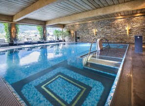 Una piscina techada, sillones reclinables de piscina