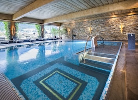 Una piscina techada, sillones reclinables de piscina