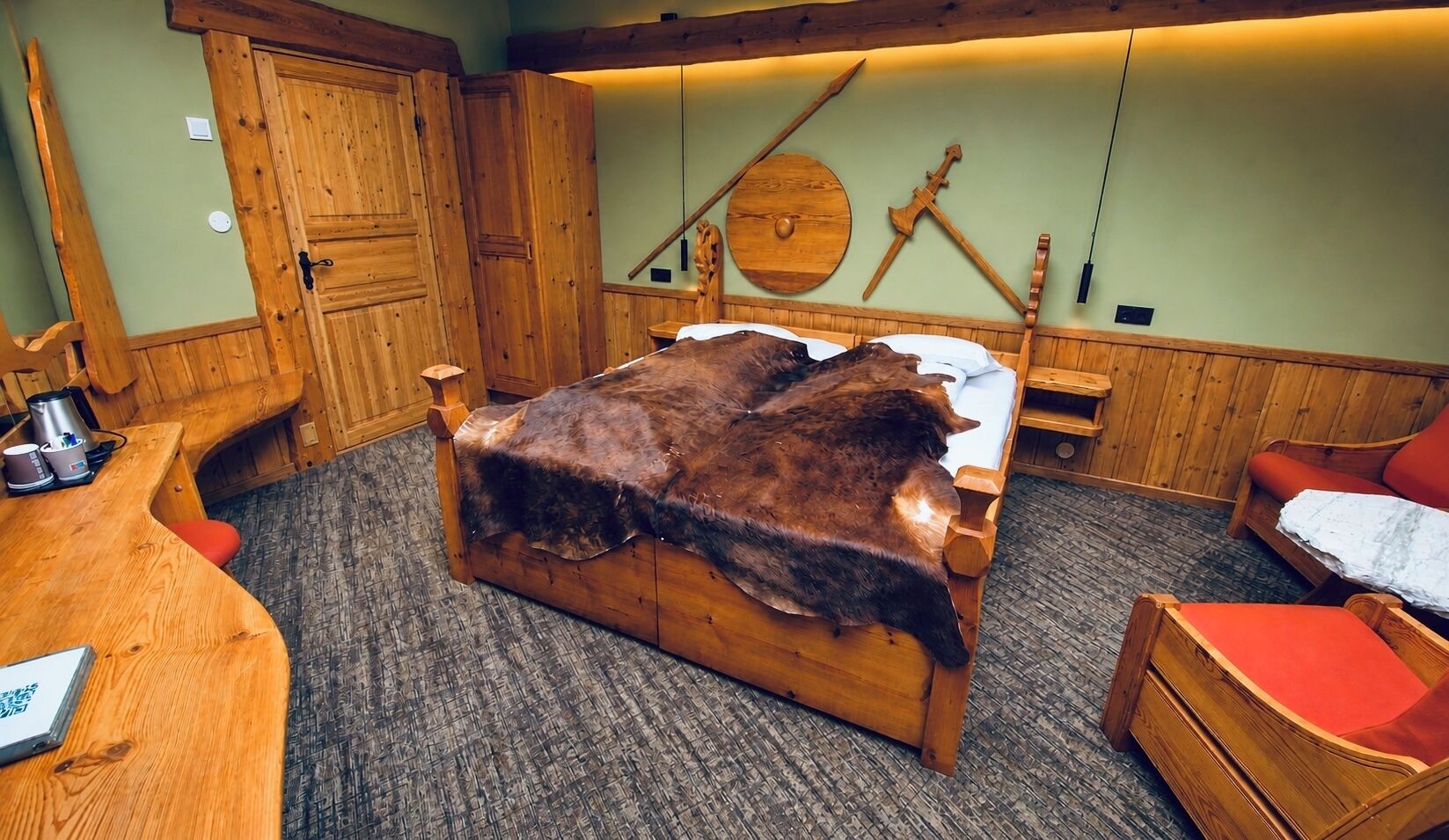 Una habitación con una cama, un escritorio y una silla de madera.