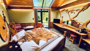Una habitación con cama, escritorio, silla y televisión.