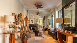 A spacious hallway with a wooden floor, a fireplace, and a seating area with a sofa and chairs. - Mountview Guest House (Cape Town)