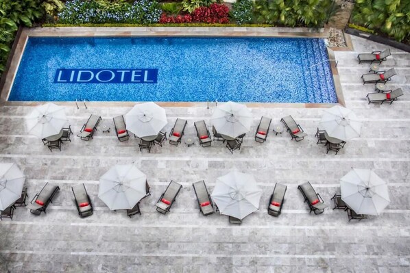 A swimming pool with the name 'LIDOTEL' and sun loungers with umbrellas arranged around it. - Lidotel San Cristobal (San Cristobal)