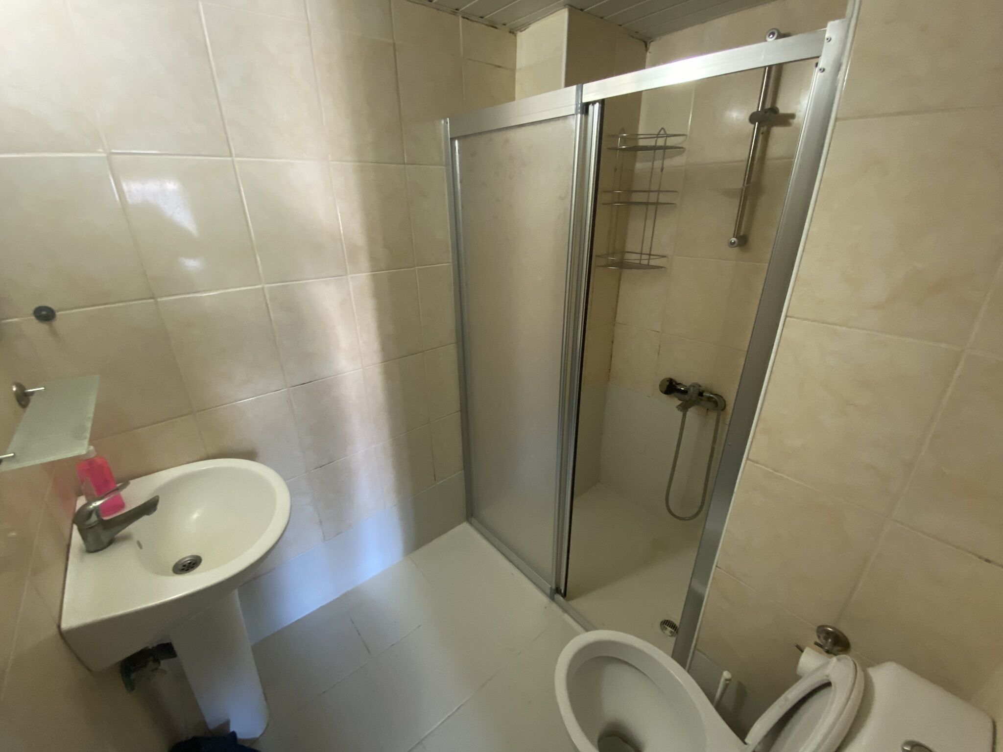 A bathroom with a shower, toilet, and sink.