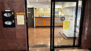 A hotel reception area with a glass door, a reception desk, and a key box labeled 'A' and 'B'.