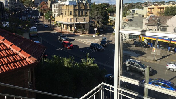 A city street with buildings, cars, and a clear sky.