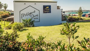 The exterior of Mollymook Shores Hotel with a sign for Thai Flavors restaurant.