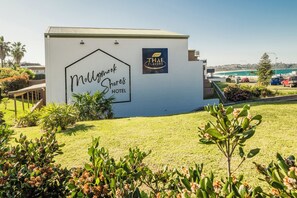 The exterior of Mollymook Shores Hotel with a sign for Thai Flavors restaurant.