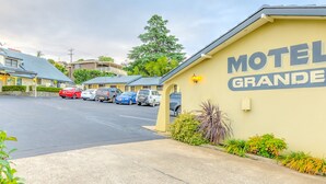 Un motel llamado 'Motel Grande', con un estacionamiento y varios coches aparcados.