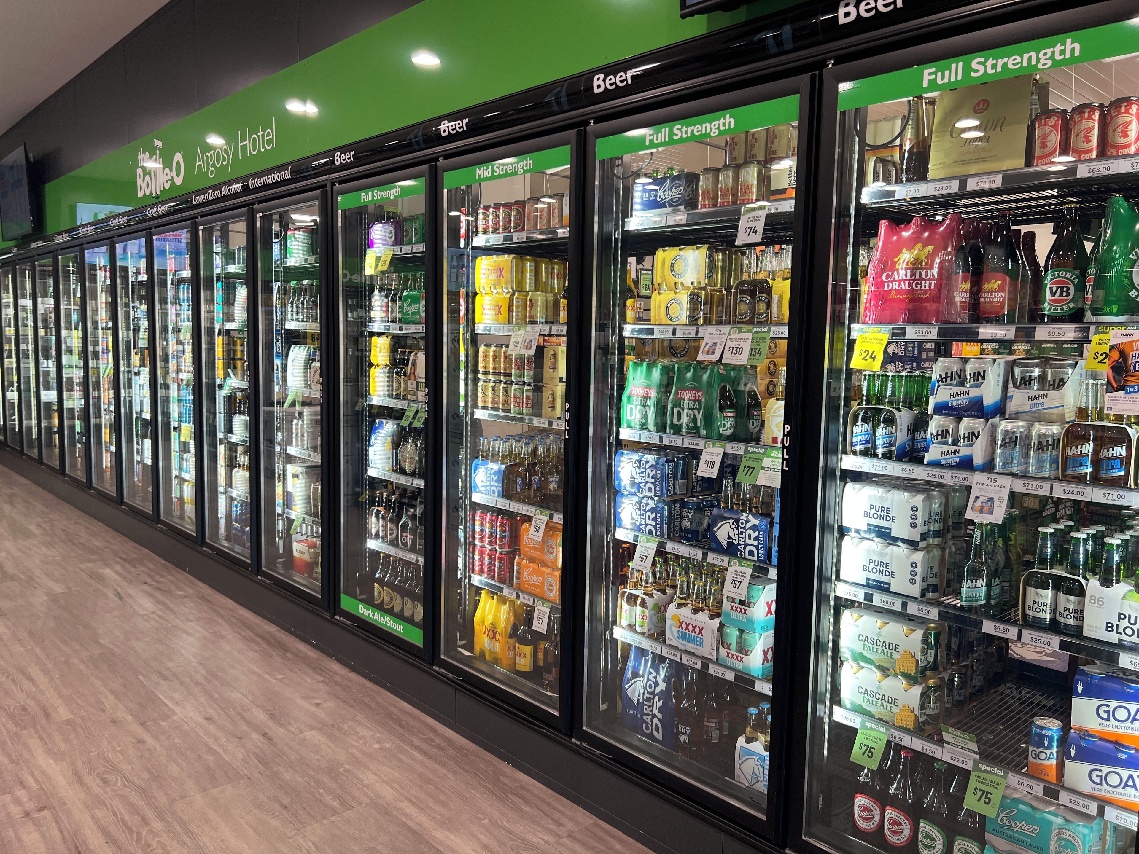 A row of refrigerated beverage dispensers in a hotel lobby.