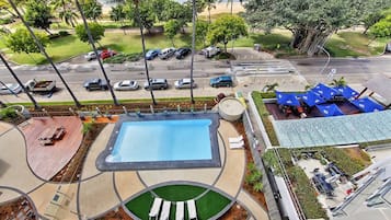 A rooftop pool area with a rectangular pool, lounge chairs, and a surrounding deck.