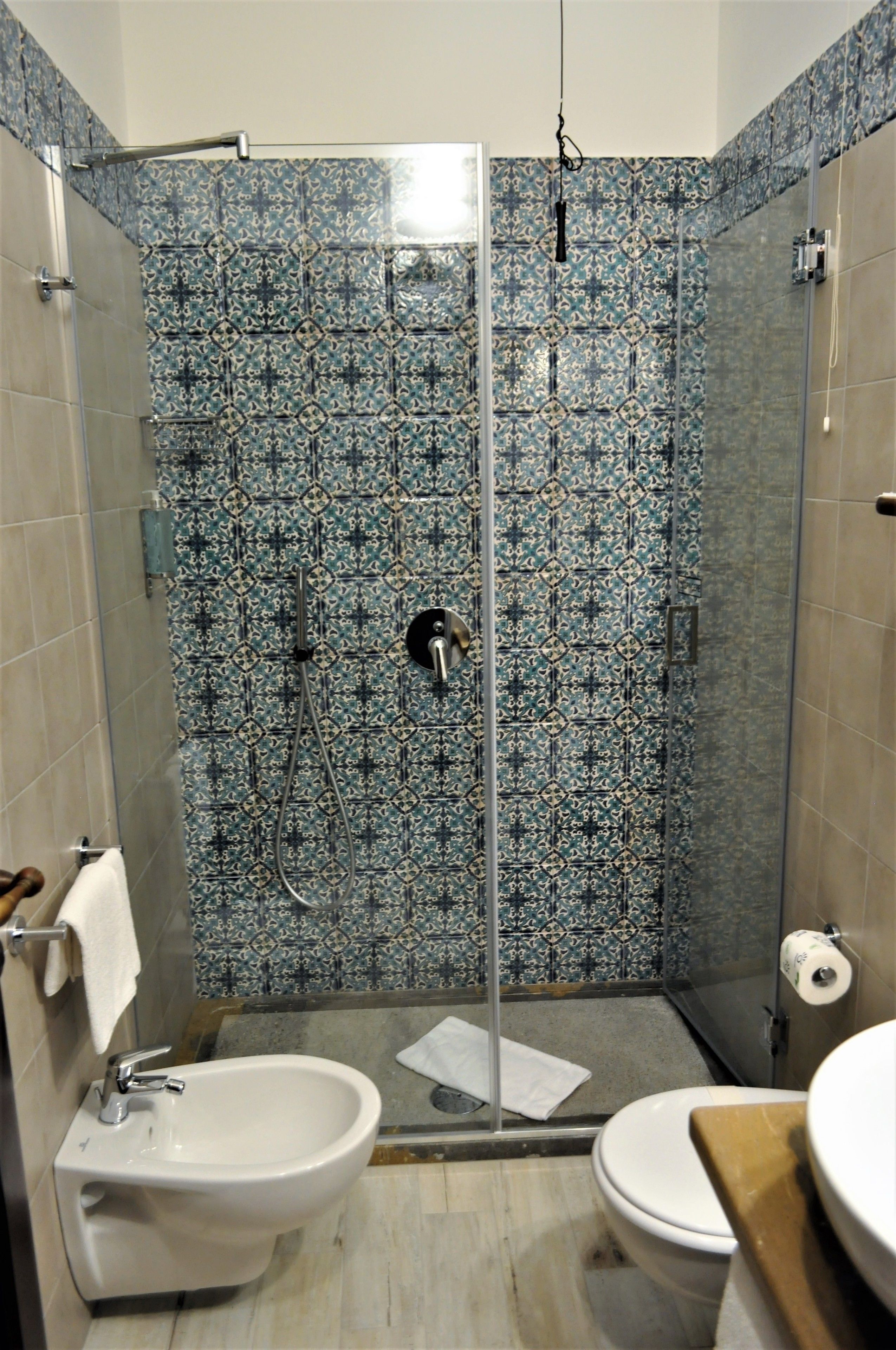 A bathroom with a shower, bidet, and toilet.