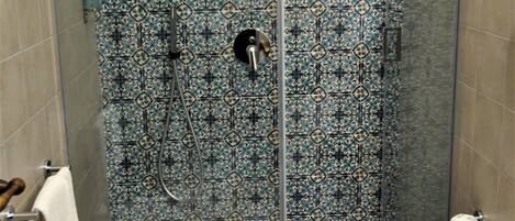 A bathroom with a shower, bidet, and toilet.