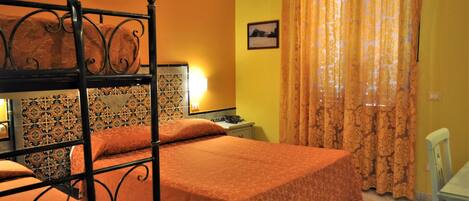 A room with a bed, a nightstand, a lamp, a chair, and a window with curtains.