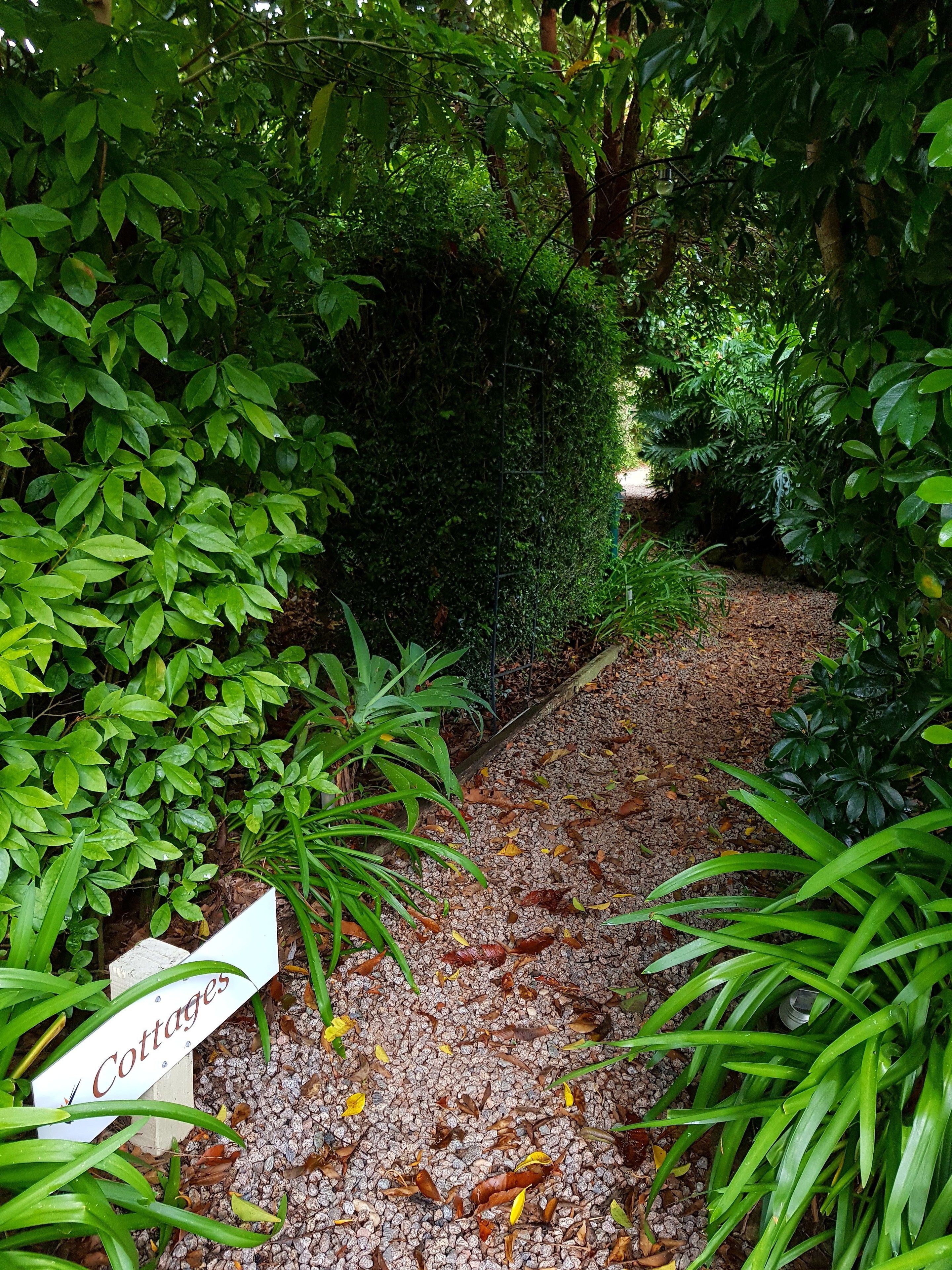 Un sentier de jardin avec un panneau indiquant « Maisons de vacances ».