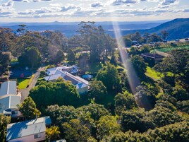 Vista aérea de una zona residencial con casas, paneles solares y abundante vegetación.