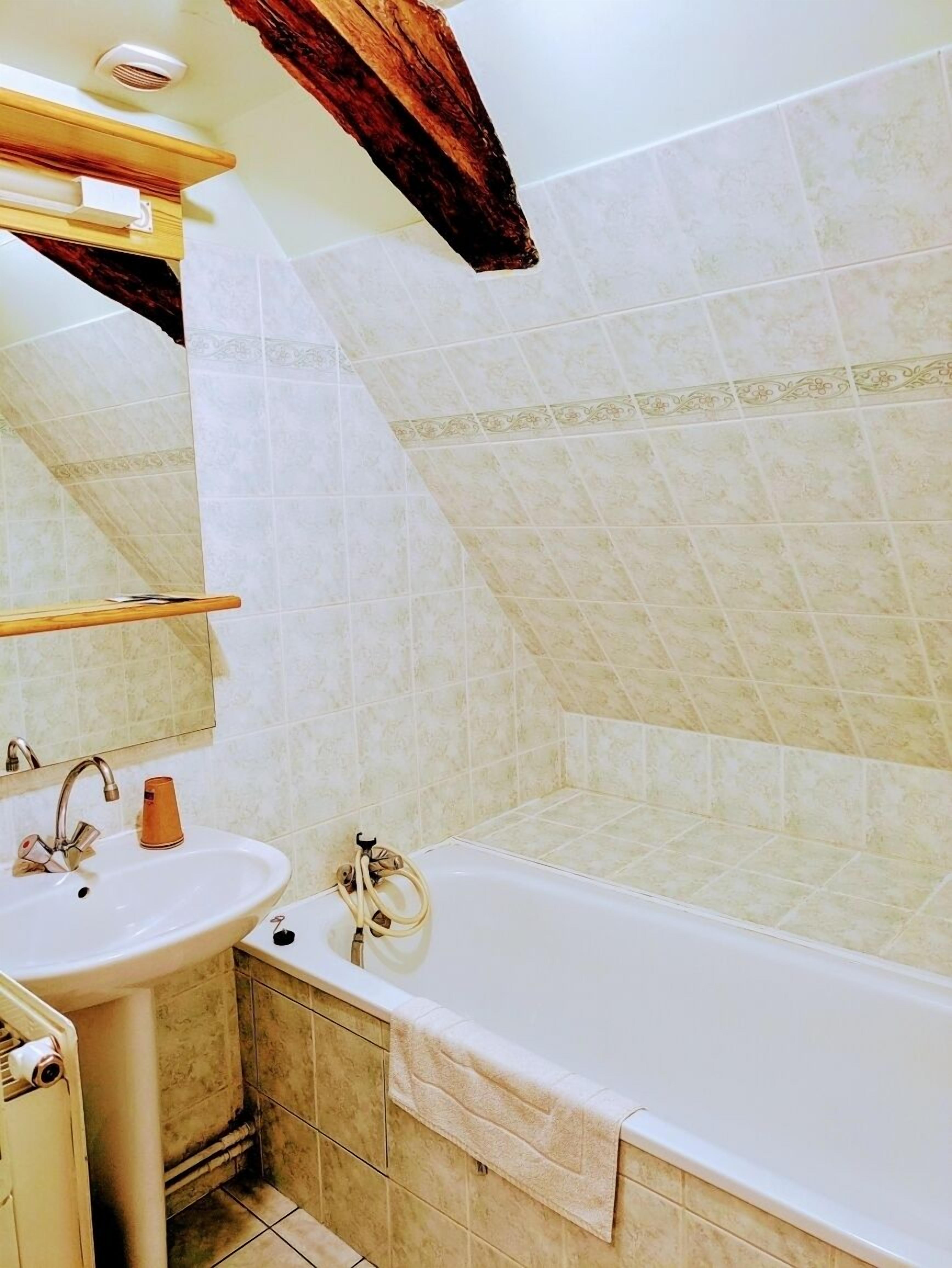 Un bagno con lavandino, specchio e vasca da bagno.
