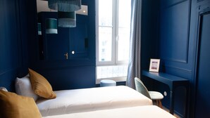 Een slaapkamer met twee bedden, een bureau en een stoel.