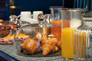 A breakfast buffet with pastries, beverages, and a variety of food items. - Hotel Petit Saint Honoré (Paris)