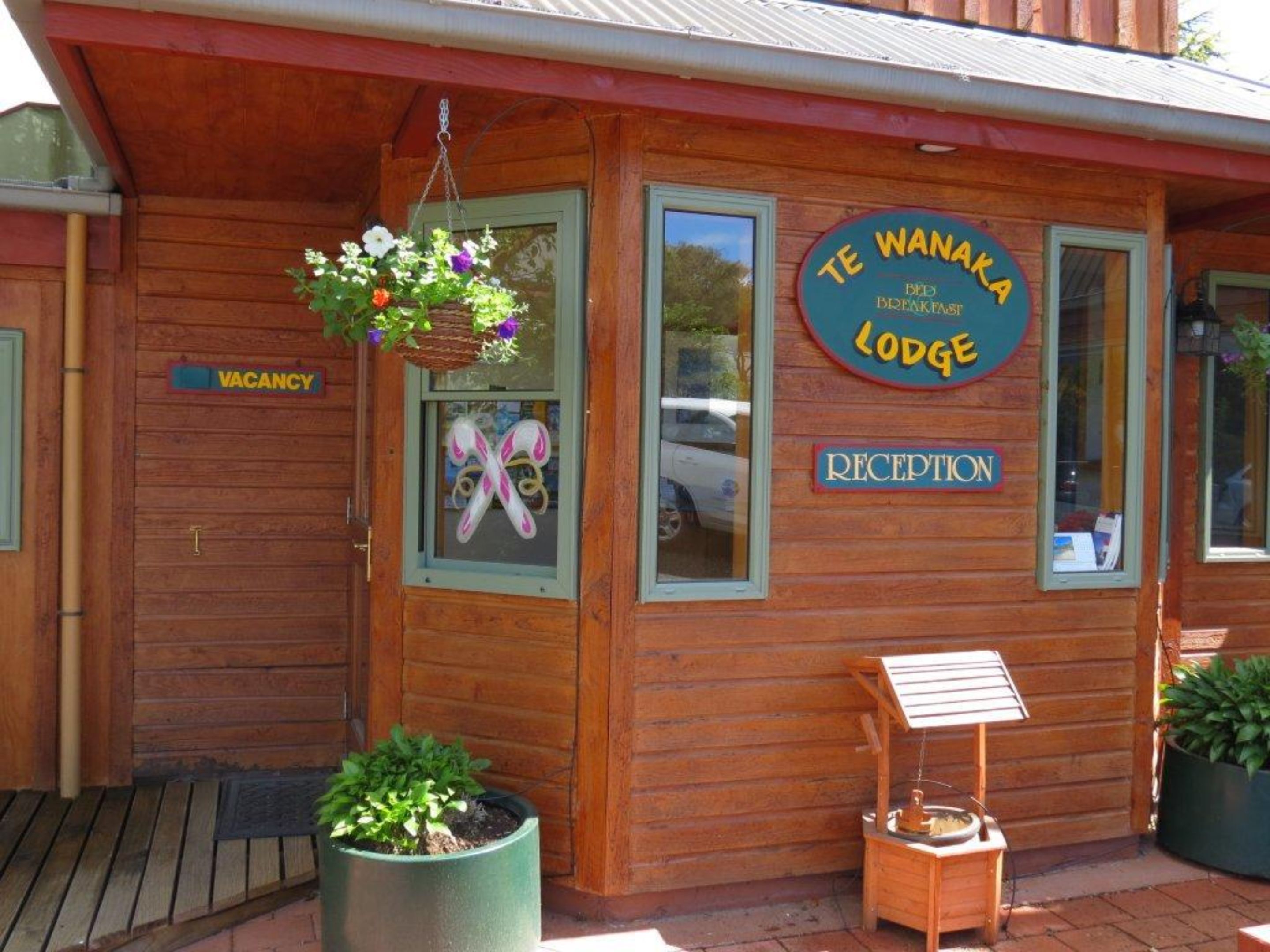 A wooden building with a sign reading "Te Wanaka Lodge" and a "Reception" sign.
