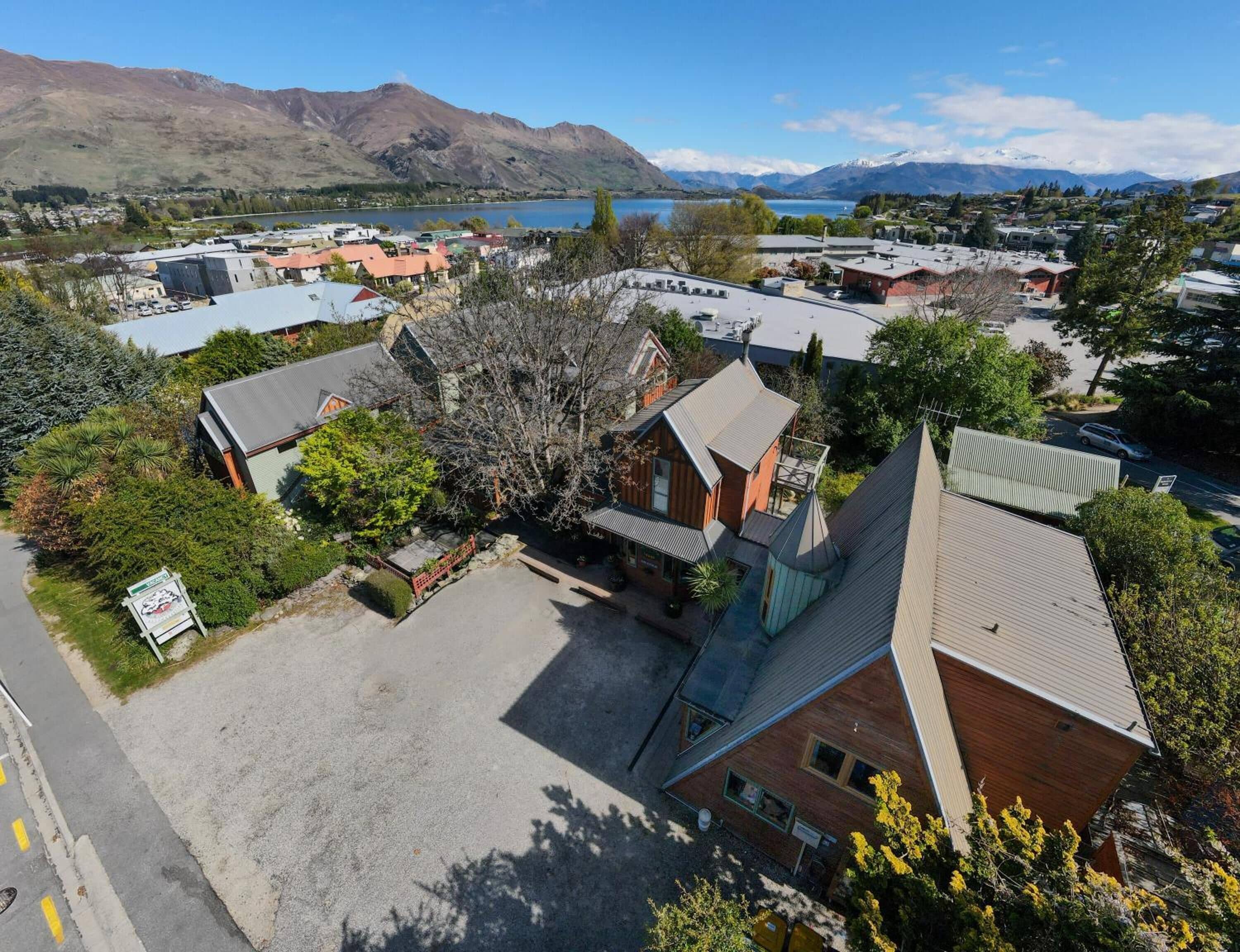 A residential area with houses, a parking lot, and a mountain backdrop.