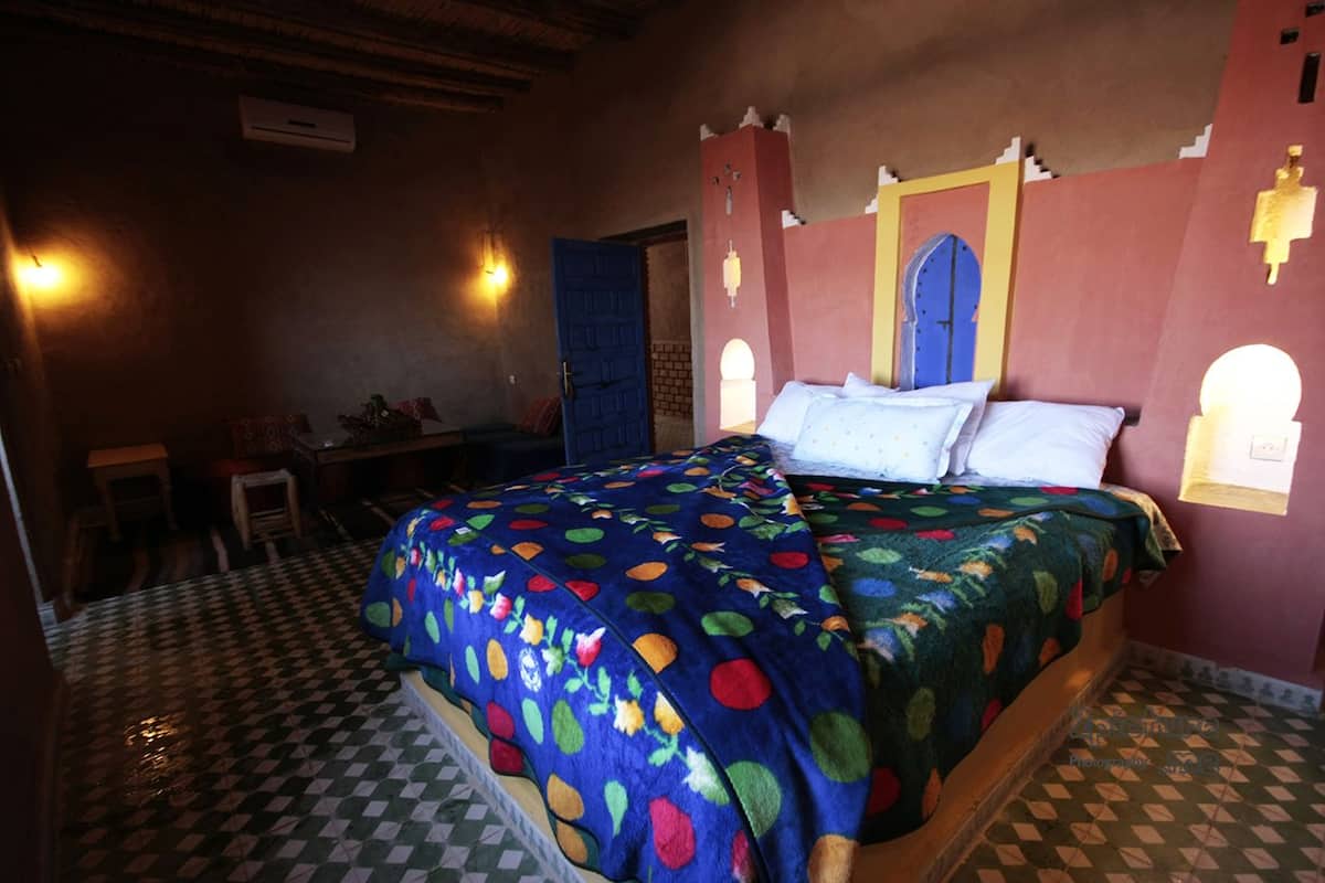Una habitación con cama, escritorio y silla.