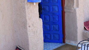 Une entrée d’immeuble avec une porte bleue et l’inscription « KASBAH » au-dessus.