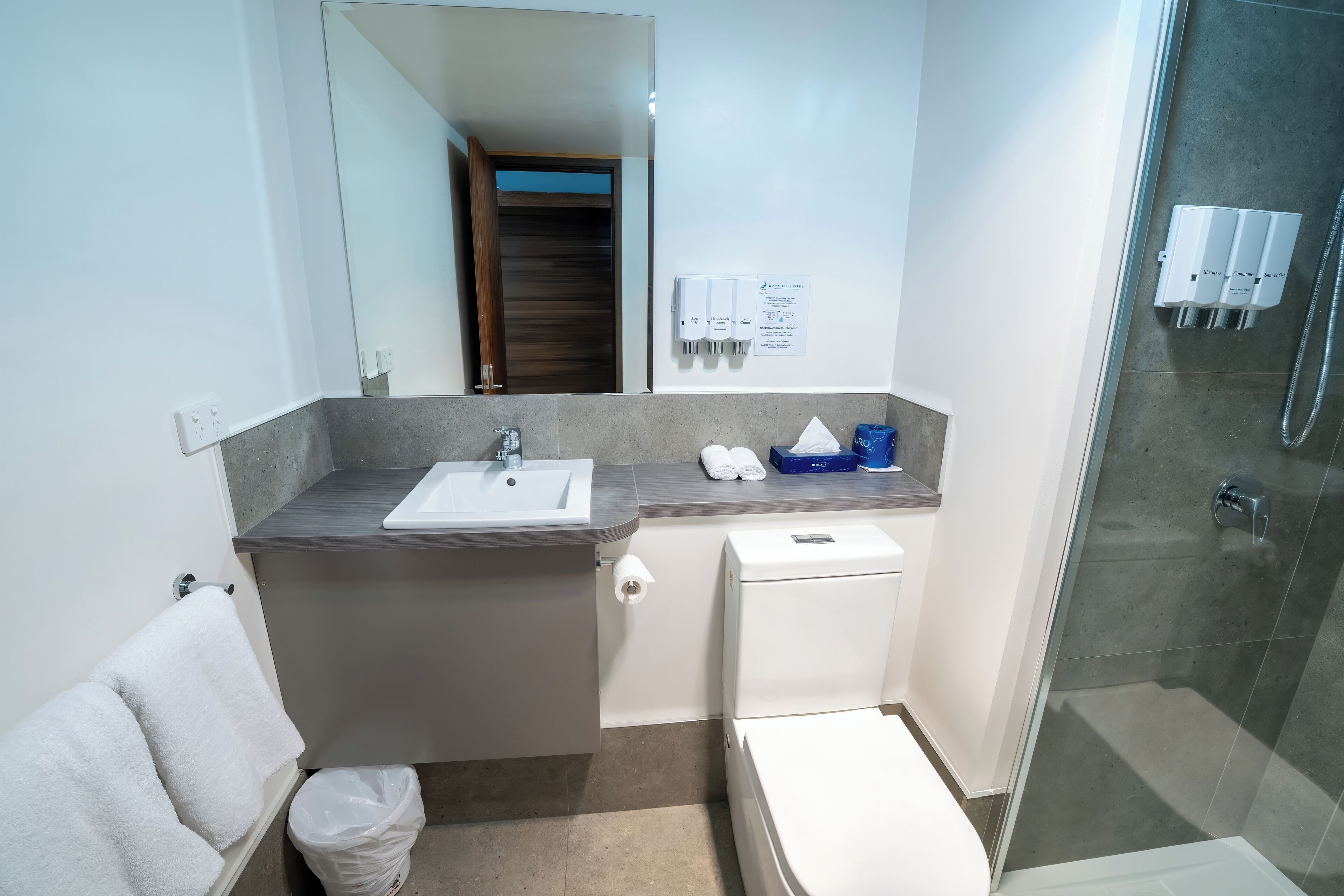 A modern bathroom with a sink, toilet, and shower.