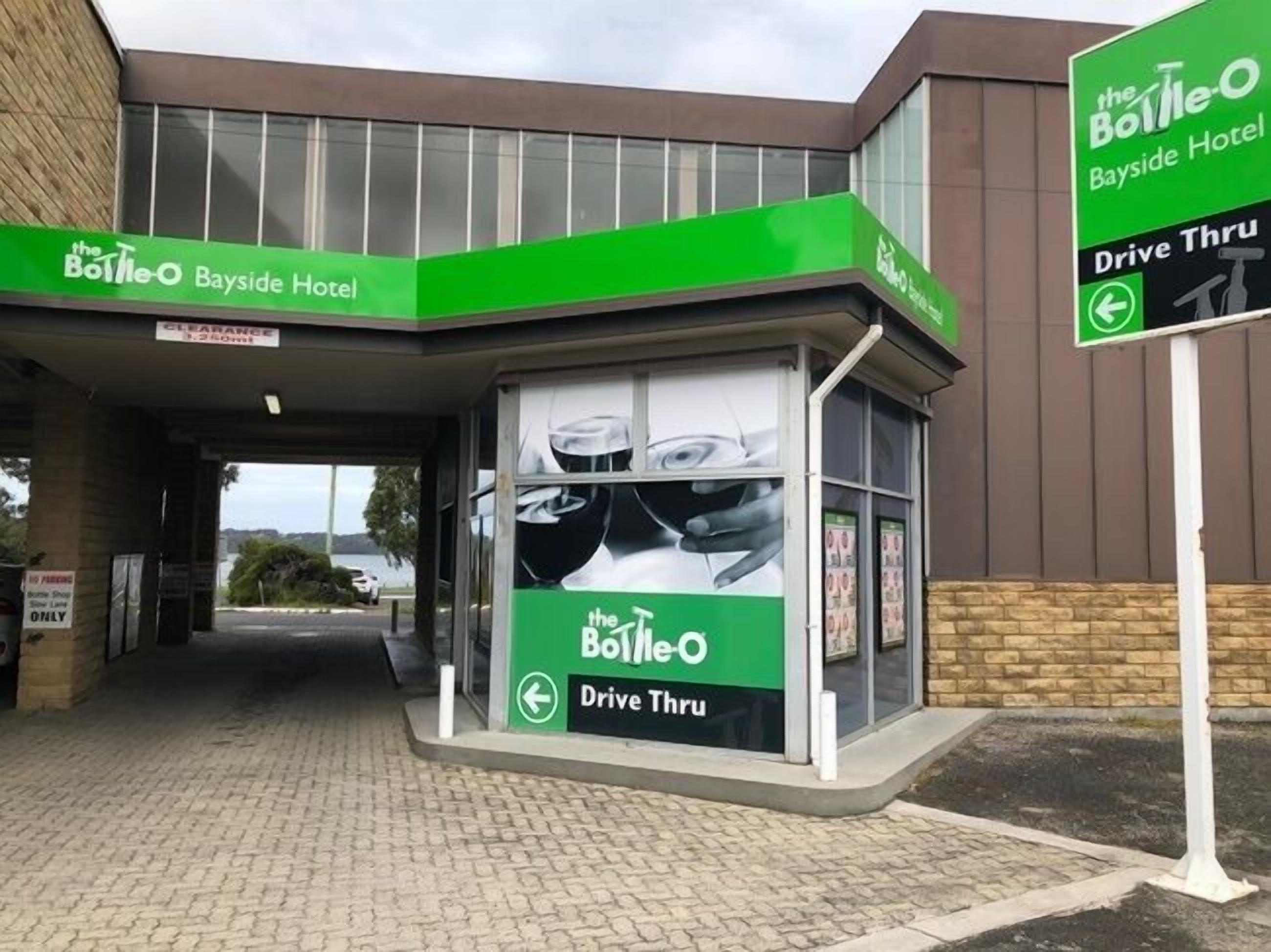 A drive-thru window of The Bottle-O Bayside Hotel with a clear view of the entrance and signage.