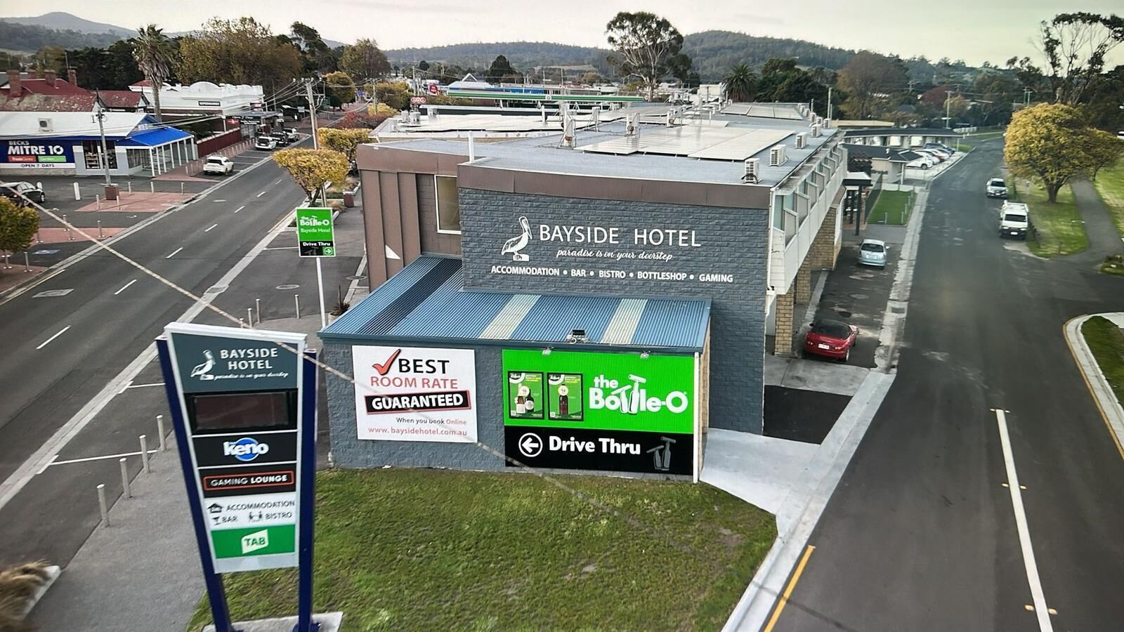 A Bayside Hotel with a sign advertising a drive-thru service.