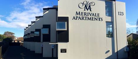 Ein modernes Mehrfamilienhaus mit einem Logo und der Aufschrift 'Merivale Apartments' an der Fassade.
