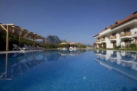 Una piscina al aire libre de temporada, sombrillas