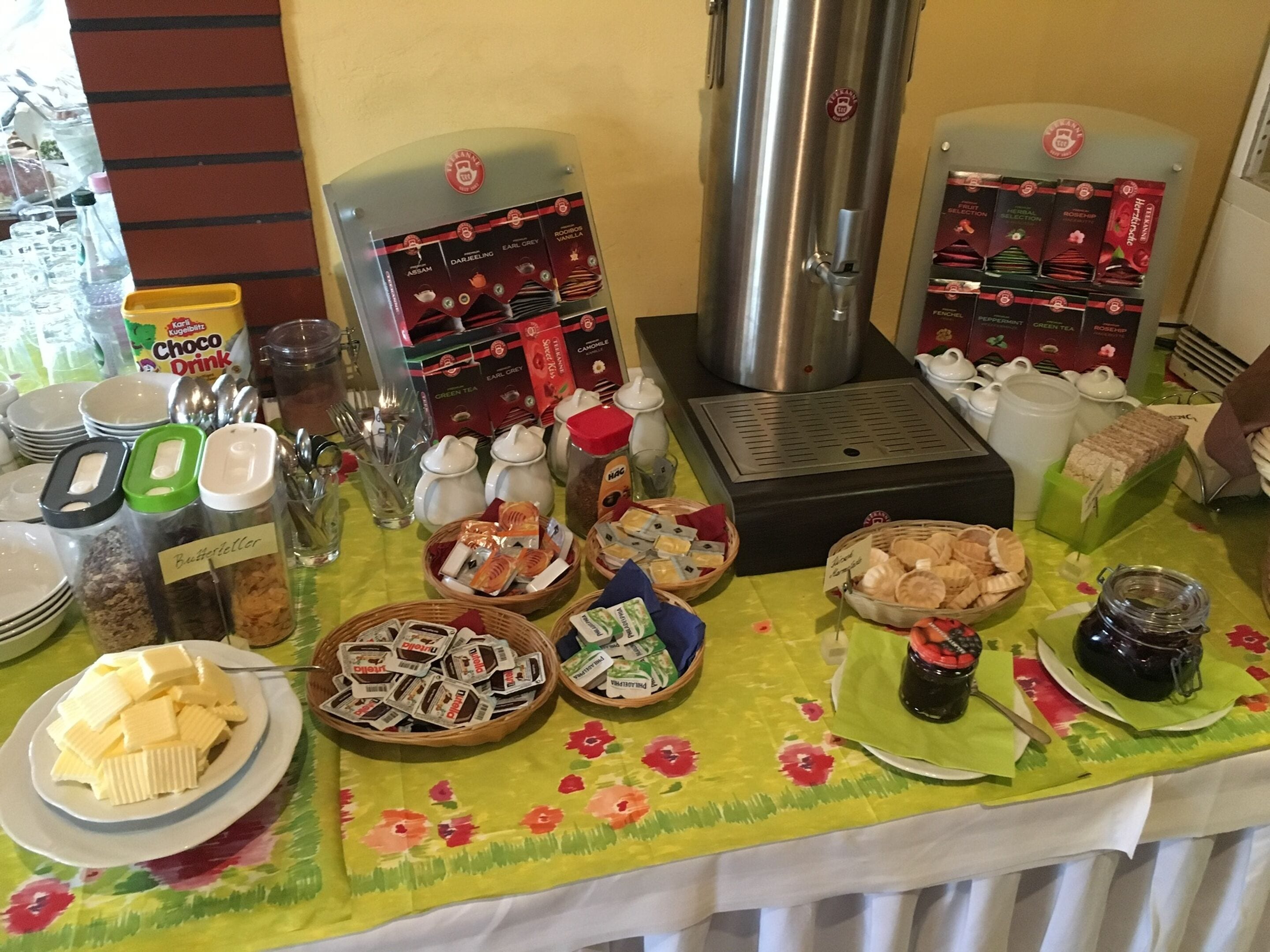 A buffet table with various food items, including butter, cheese, and packaged snacks.