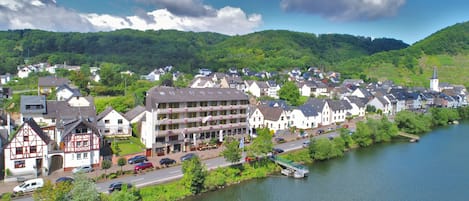 A riverside town with traditional buildings, a bridge, and a church.