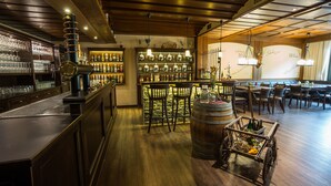 Un espace bar avec des meubles en bois, des étagères remplies de bouteilles et un comptoir.
