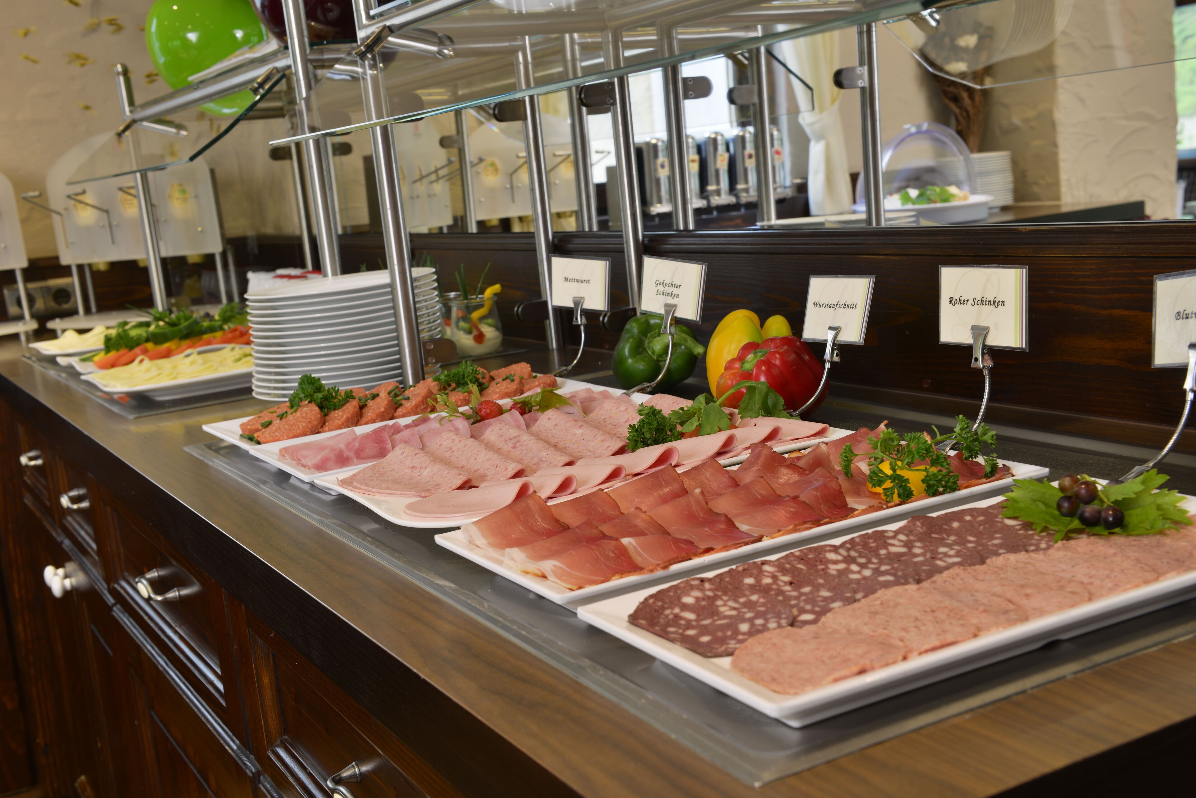 A buffet with various meat and vegetable platters.