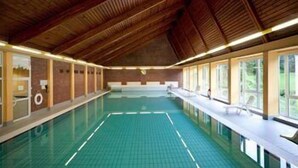 An indoor swimming pool with a wooden ceiling and a tiled floor. - Fröbelhof (Bad Liebenstein)