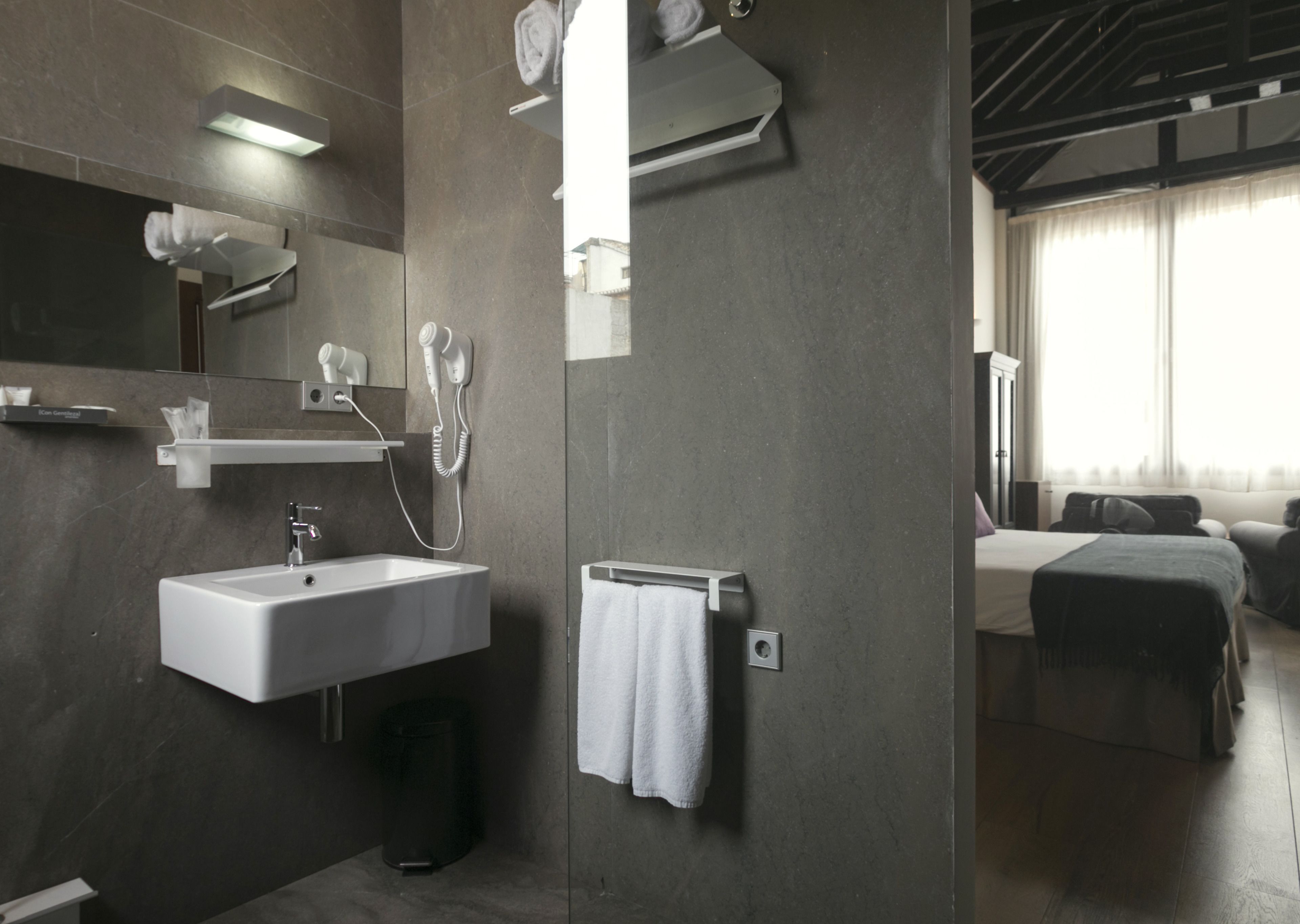 Une salle de bain moderne équipée d’un lavabo, d’un porte-serviettes et d’un sèche-cheveux.