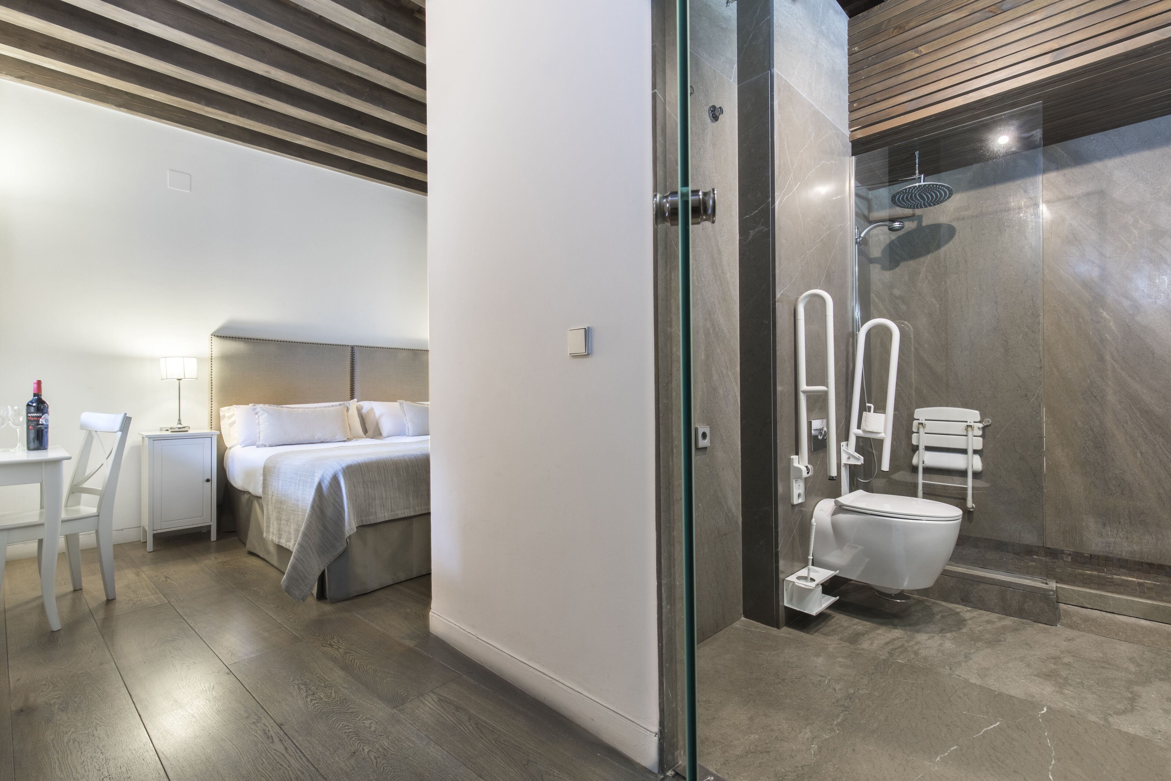 A modern bathroom with a glass shower enclosure, a toilet, and a sink.