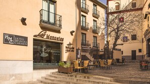 Et hotel kaldet "Los Manuales" med udendørs siddepladser og en trappe til indgangen.