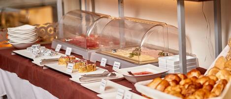 A buffet with various food items and utensils.