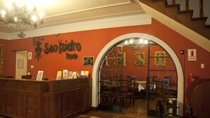 A reception area with a check-in counter, a chandelier, and a staircase leading upstairs. - San Isidro Inn (Lima)