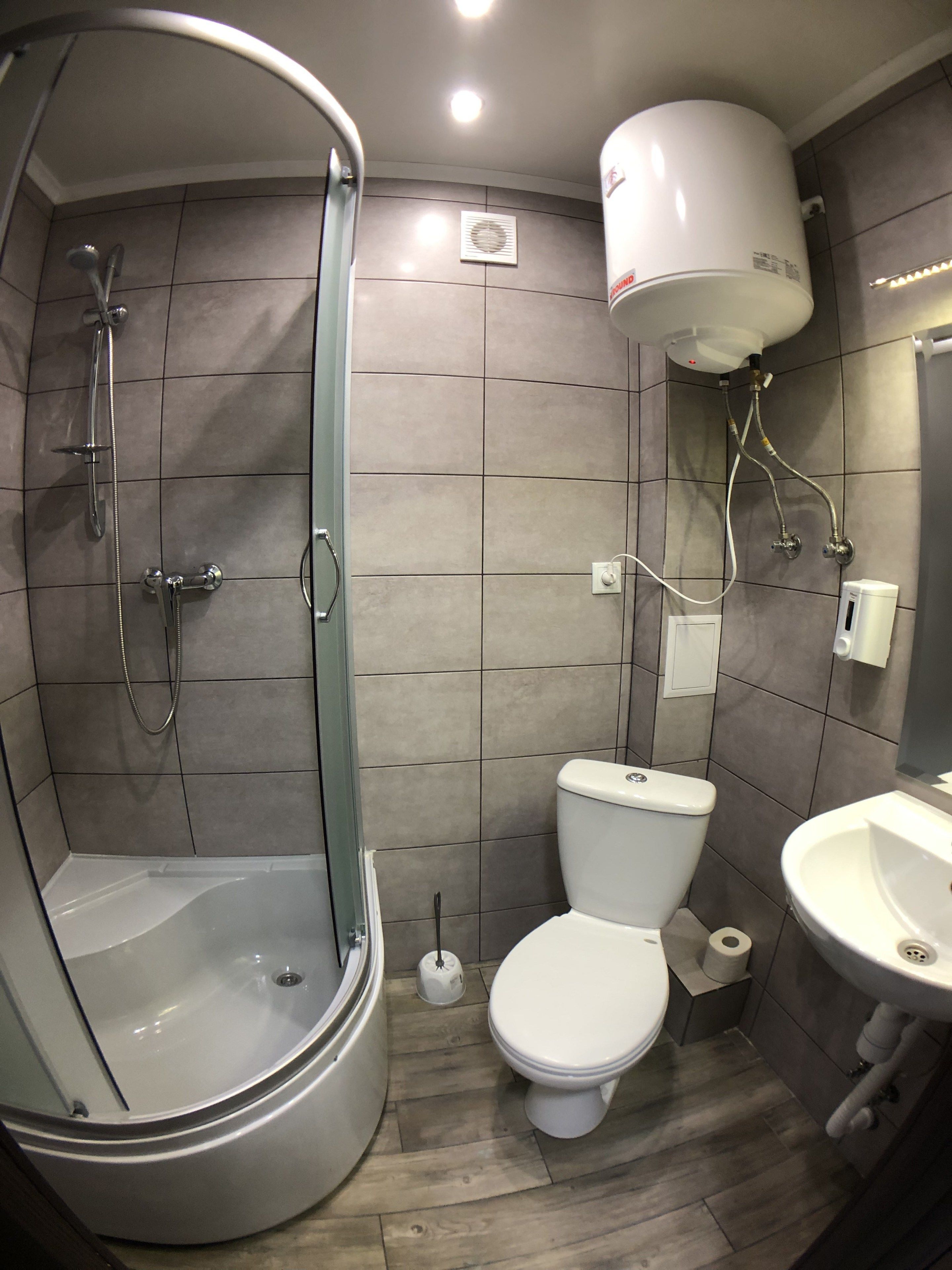 A modern bathroom with a walk-in shower, a toilet, and a sink.
