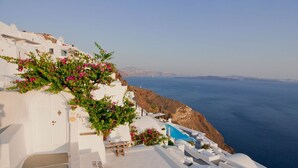 Un edificio blanco con piscina y escalones que bajan al mar.