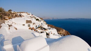 Un pueblo costero blanco con edificaciones en un acantilado con vista al mar.